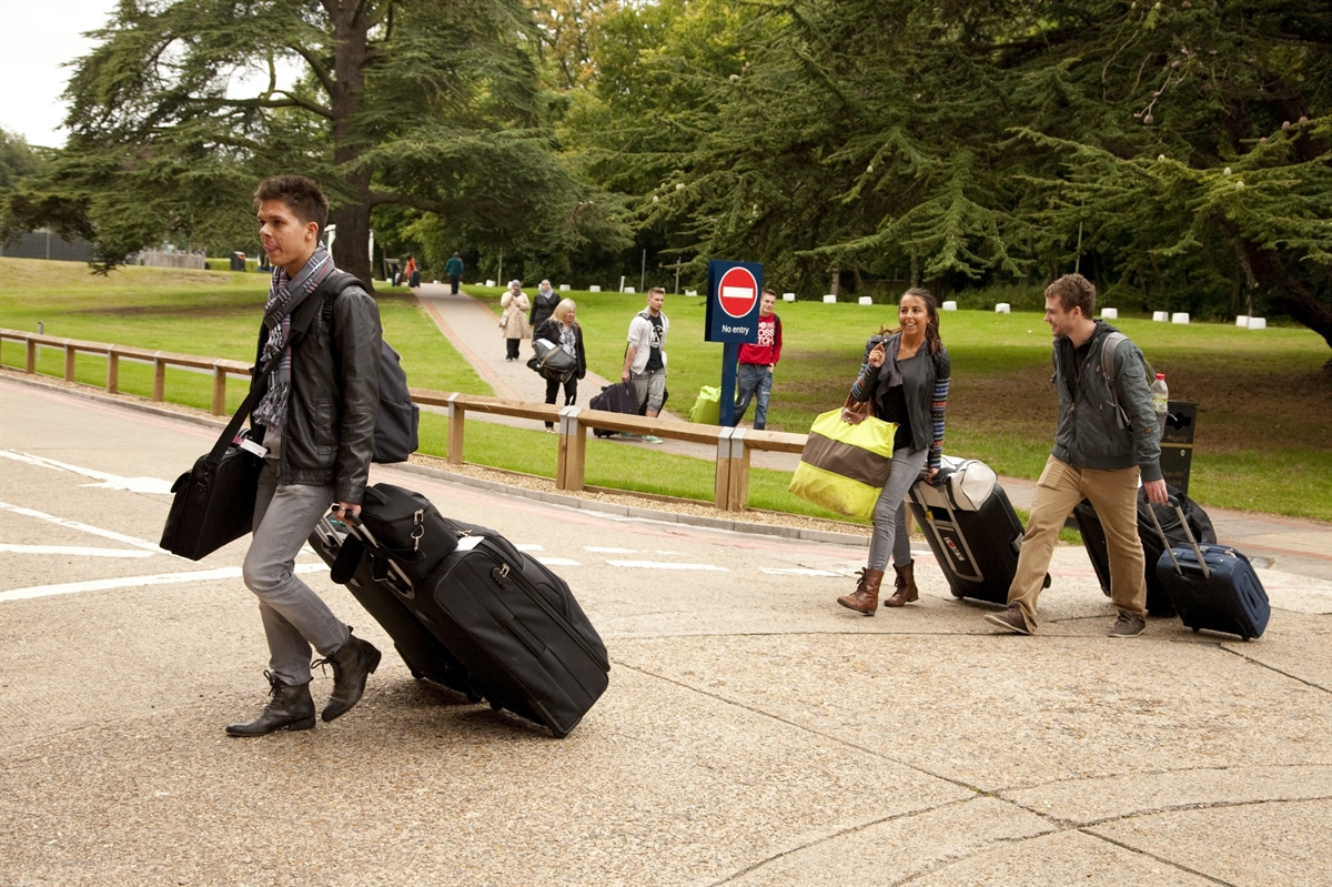 New students moving in to Founder's Building with luggage