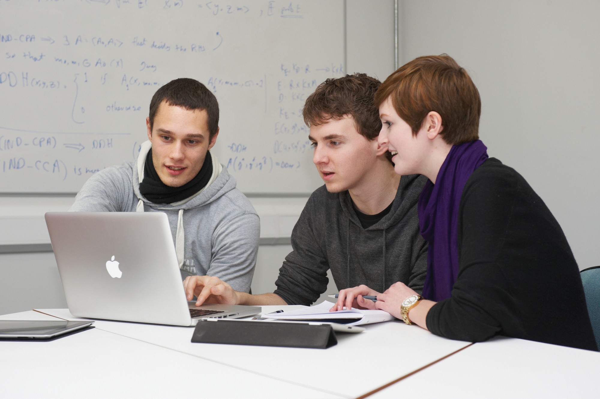 Students looking at laptop in seminar